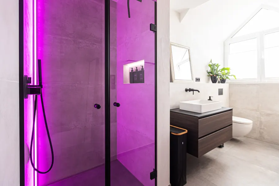 Bad mit breiter Walk-in-Dusche, Glaswand und Waschtisch nach der Sanierung